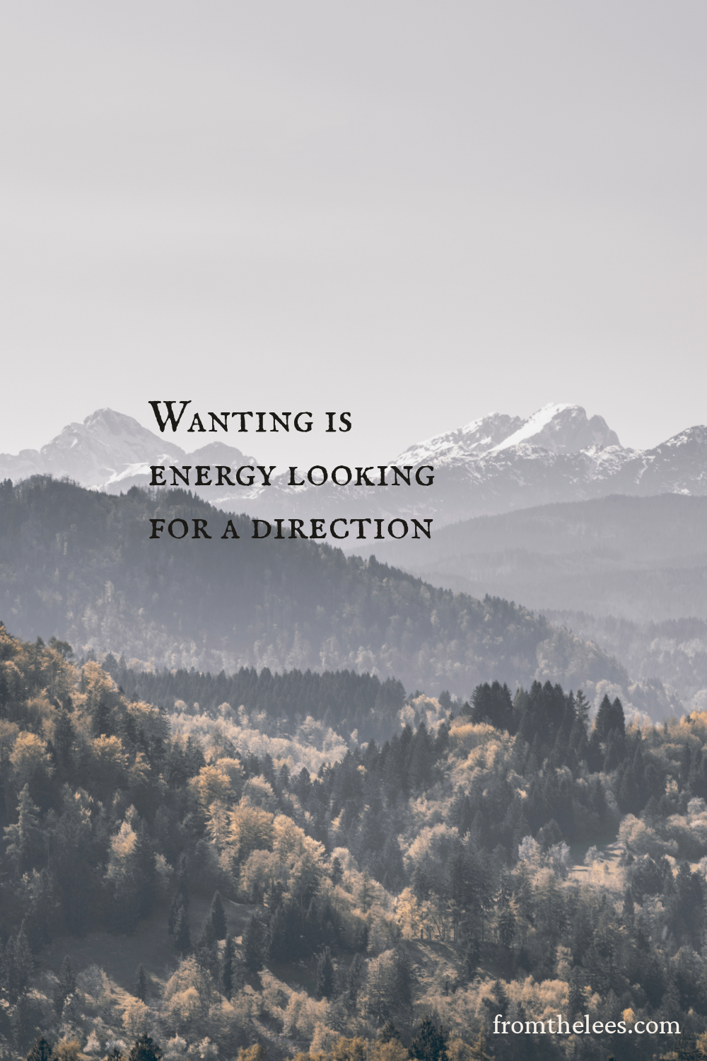 A layered mountain landscape with snow-capped peaks rising above forested hills beside the words, "Wanting is energy looking for a direction." Soft haze and muted earth tones create a spacious, contemplative scene that evokes possibility, purpose, and quiet forward movement.